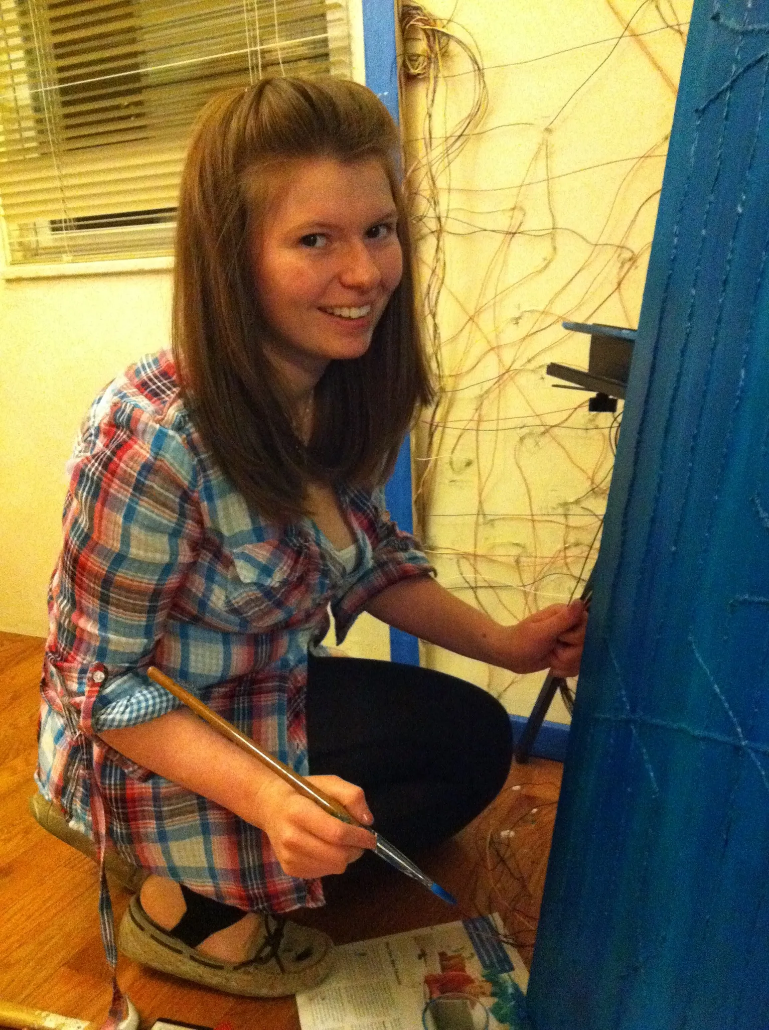Ingrid painting a blue artwork
